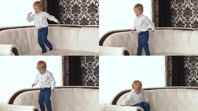 小男孩在白色皮沙发上跳跃。
