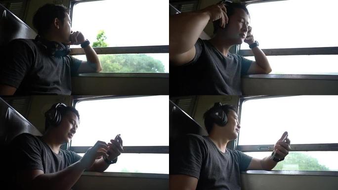 亚洲背包客男子在当地火车上听音乐