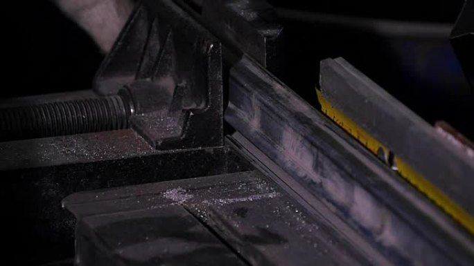 用冷却剂加速工业带锯条的动作镜头，显示运动模糊。带锯条的冷冻动作镜头显示牙齿和冷却剂。带锯机在工作。