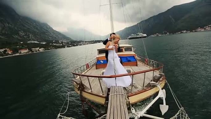 婚礼夫妇拥抱在布德瓦黑山海上航行的船尾