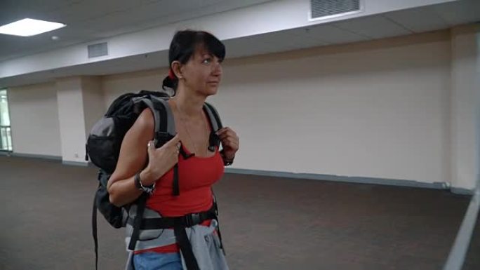 女人在空荡荡的机场走廊上行走