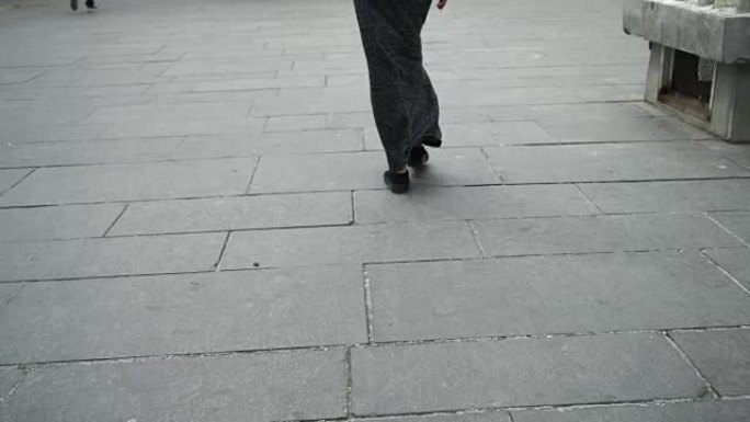 在城市行走的腿女人。不穿高跟鞋的休闲便鞋