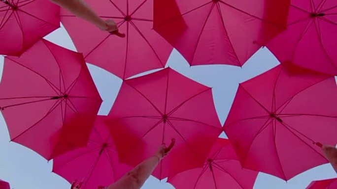 天空中打开的粉红色雨伞作为装饰