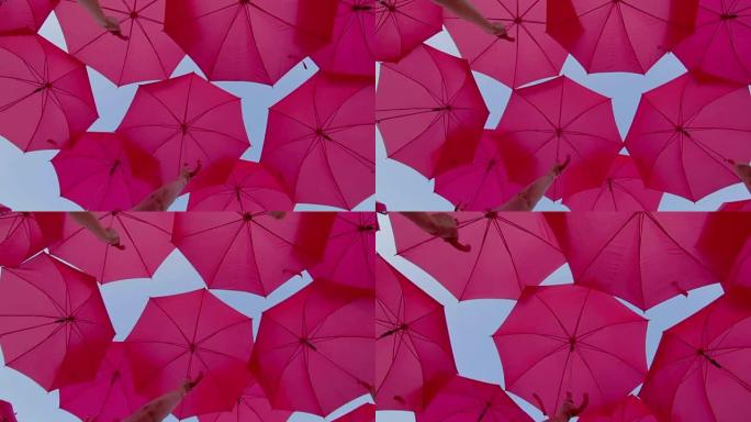 天空中打开的粉红色雨伞作为装饰