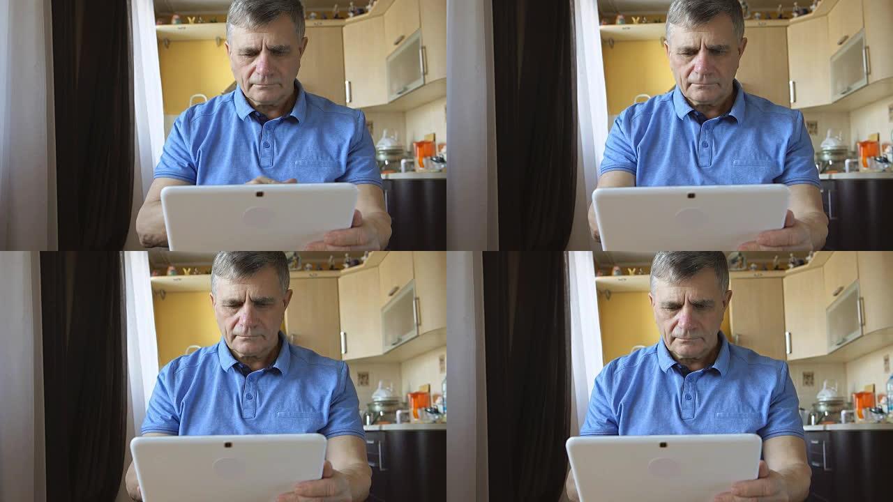 一位老人的肖像在家中键入平板电脑