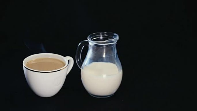 白色杯子里的咖啡黑色背景上的小水罐里的牛奶