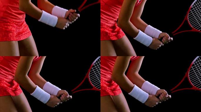 一名女子网球运动员的身体期望在黑色背景上服役