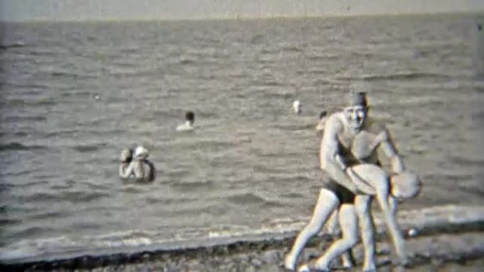1937: 爸爸和女儿在沙滩上玩，戴着泳帽。