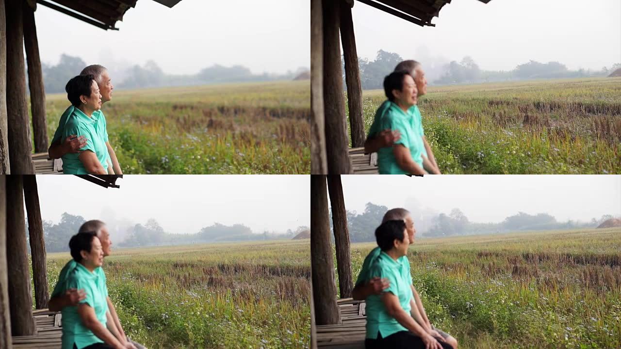亚洲老年夫妇坐在稻田旁边的凉亭里。农场和农业业务