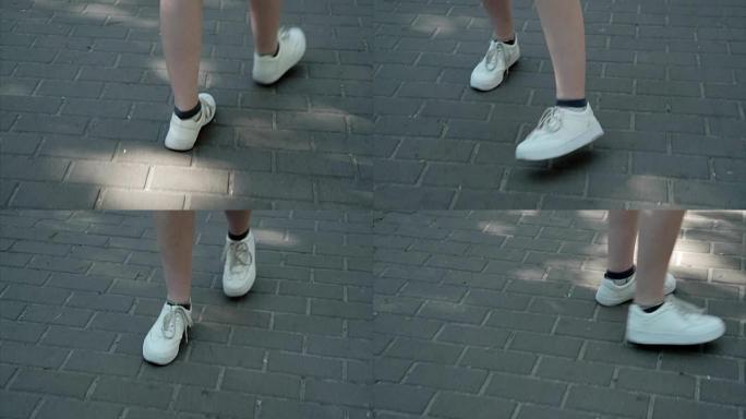 穿着运动鞋的年轻漂亮的女性脚在炎热的天气里走在瓷砖形状的菱形夏天