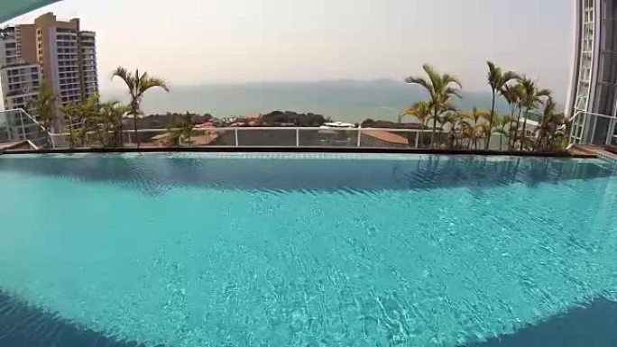 豪华热带酒店美丽清新的蓝色游泳池水。晴天棕榈。动作摄像机
