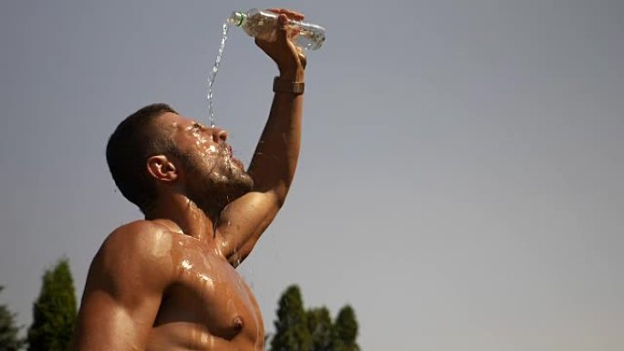 口渴出汗的家伙在炎热的夏天将水倒在他的头部和身体上降温