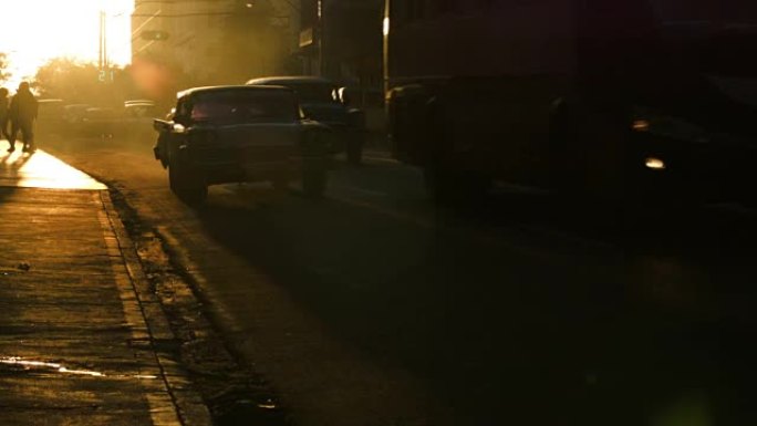 哈瓦那日落中的行人和汽车发光剪影