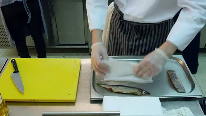 厨师用餐巾包裹新鲜的鱼