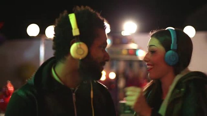 男人和女人戴着耳机随着音乐的节奏跳舞