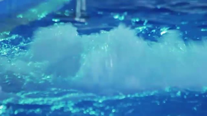 水溅在热水浴缸里。蓝色游泳池里的涟漪水