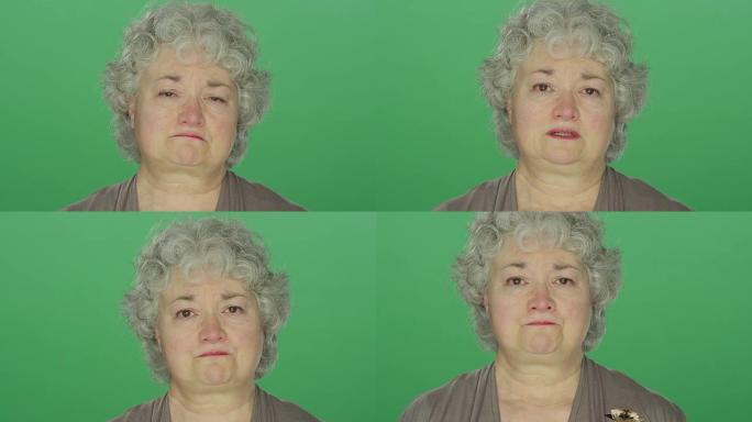 在绿屏工作室背景上，年长的女人眼泪汪汪