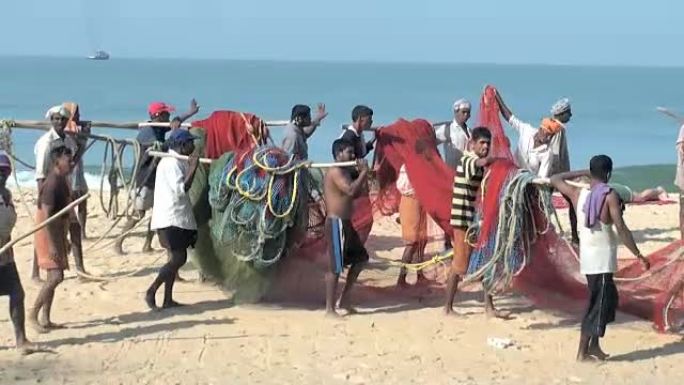 印度渔民肩负着庞大而沉重的网络