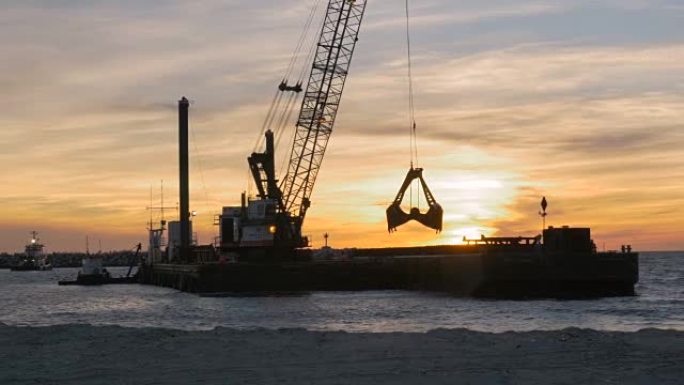 挖泥船在日落时从海底清除沙子