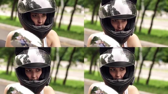 骑摩托车戴头盔的年轻女孩的肖像。