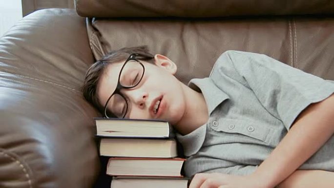 小男孩睡在书堆上