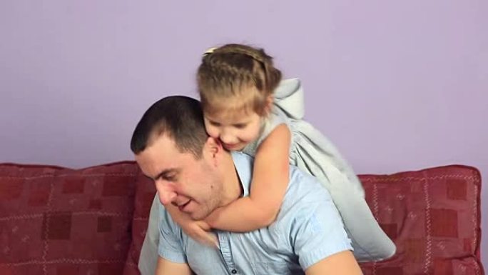 快乐的父亲和女儿在沙发上打架枕头