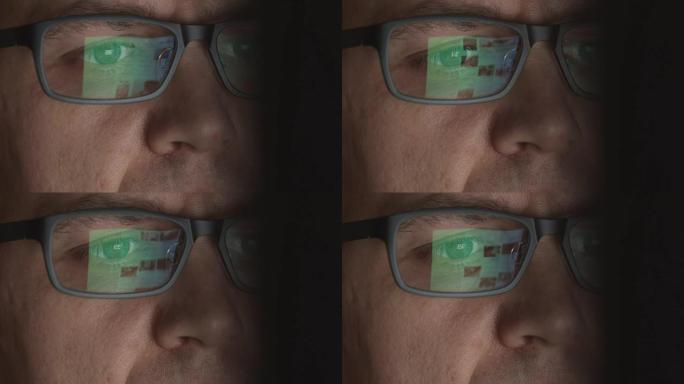 在计算机上工作的成年男子的眼镜中反映滚动站点