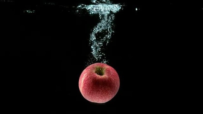 苹果，家蝇，黑色背景下进水的水果，慢动作4K