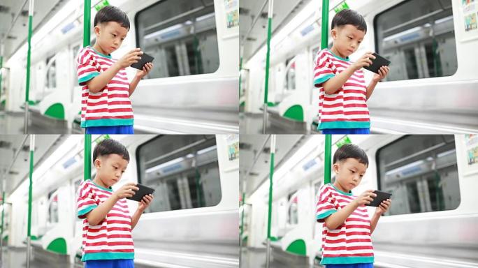 在地铁中使用智能手机的男孩