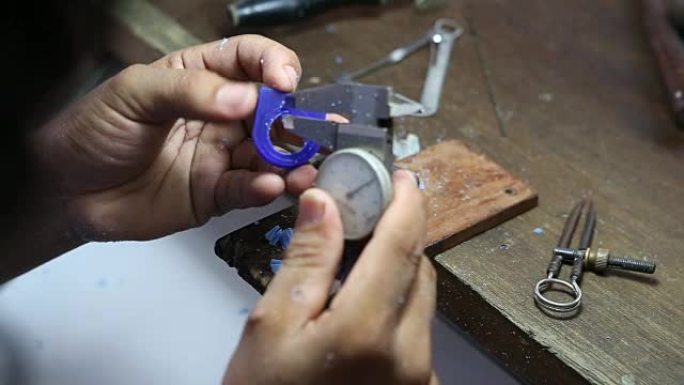 珠宝工匠使用游标卡尺标记和测量环形蜡模