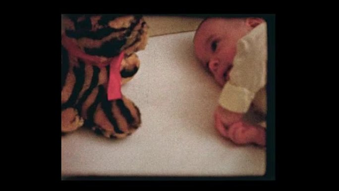 婴儿床里有填充动物的2个月大婴儿男孩