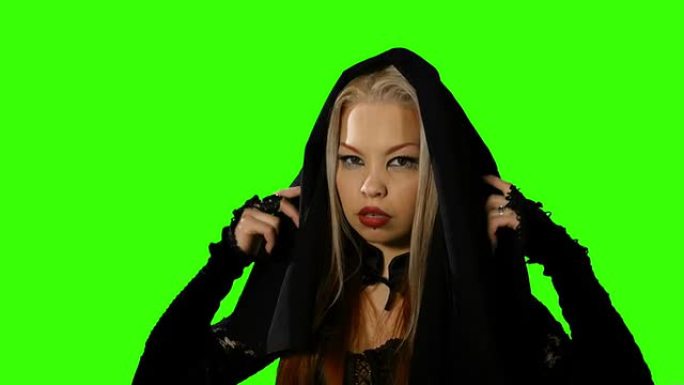 女性吸血鬼移除了绿屏上的黑色面纱。万圣节。