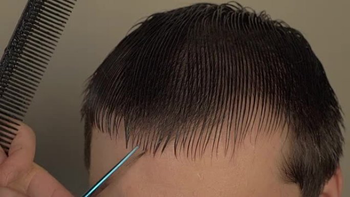 男性理发师剪客户的湿头发