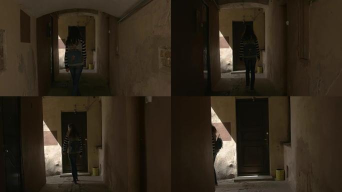 女人沿着黑暗的走廊走。