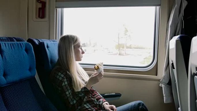 火车旅行时吃三明治的美女