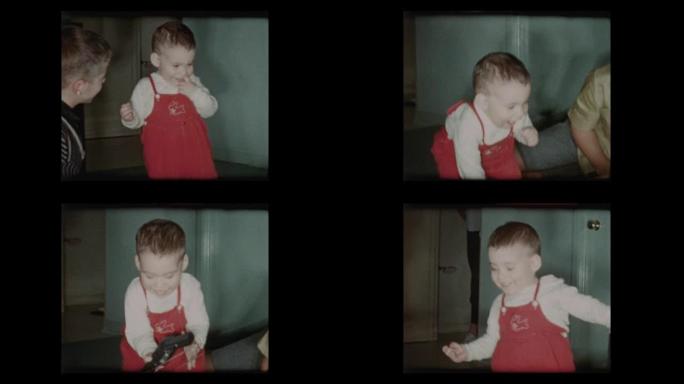 蹒跚学步的小男孩穿着红色工作服，带玩具枪1960