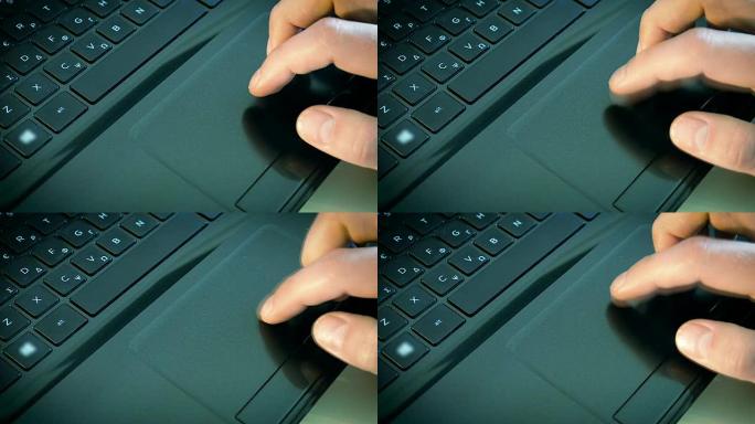 在笔记本电脑上使用触摸板的特写男性手
