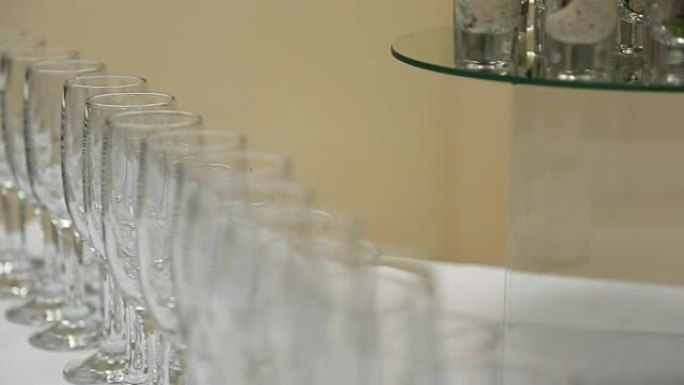 玻璃酒杯或香槟站在桌子上，用一块带陶瓷板的白布