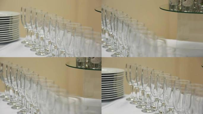 玻璃酒杯或香槟站在桌子上，用一块带陶瓷板的白布