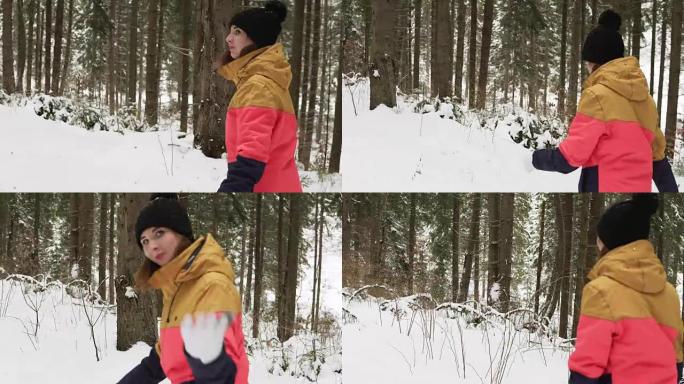 快乐微笑的女人穿着冬衣在森林里的户外出现微笑，用手挥手致意