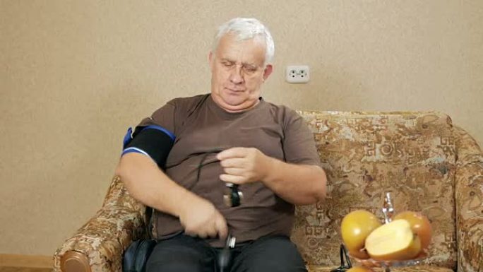超重的人在沙发上测量自己家的压力。他通过血压计听脉搏