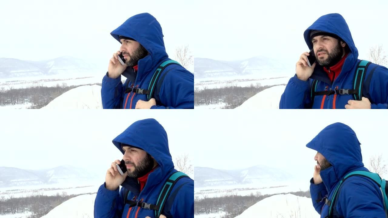 山上有胡子会说话的智能手机的旅行者。穿着夹克的白人男子在寻找全球定位系统信号。登山者冬季移动通信。冒
