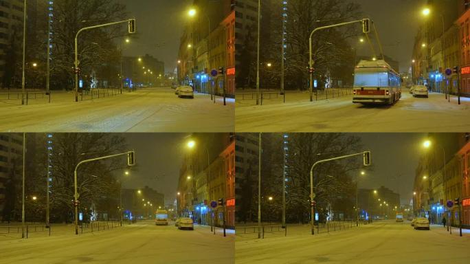 电动巴士在中欧白雪覆盖的街道上行驶，夜晚