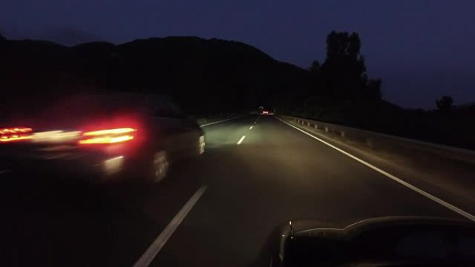 在漆黑的夜晚在乡村道路上行驶，大灯打开，pov