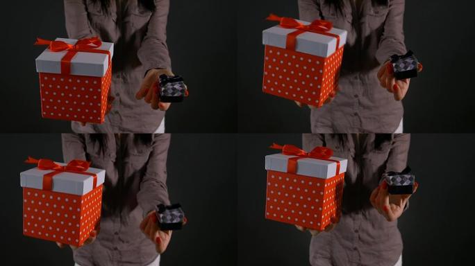 一个女人的手拿着一个大礼品盒和一个小礼品盒可供选择