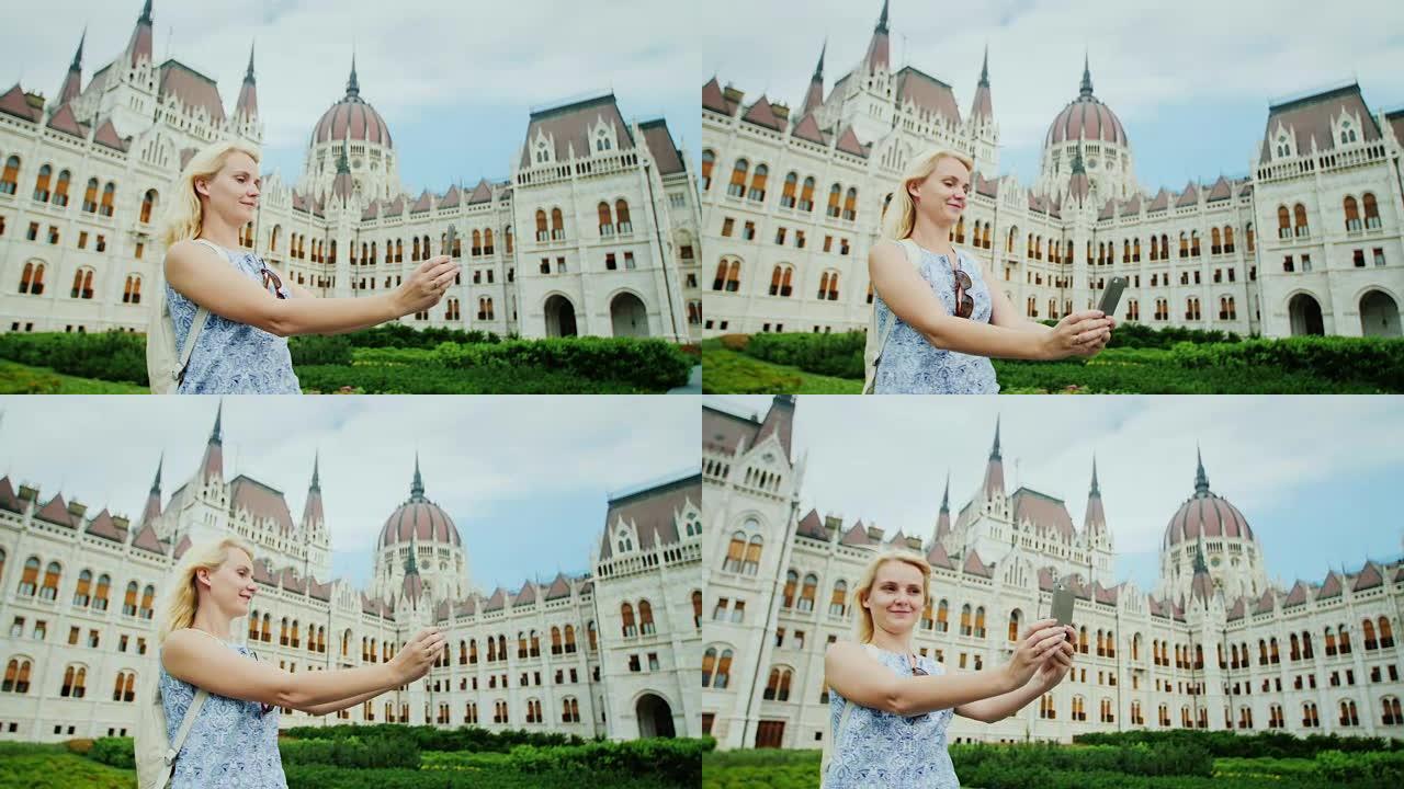 宏伟的布达佩斯。年轻女子在布达佩斯匈牙利议会的背景下拍照