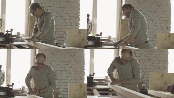 老木匠用特殊海绵硬抛光木板表面。制造商