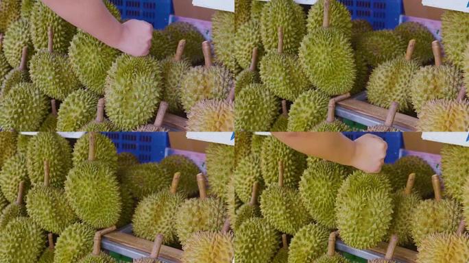 一个小贩挑选榴莲水果卖给当地市场街的顾客。榴莲在东南亚被许多人视为水果之王。