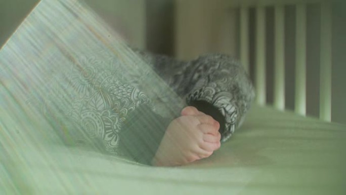 婴儿的脚在床上用镜头光晕抖动