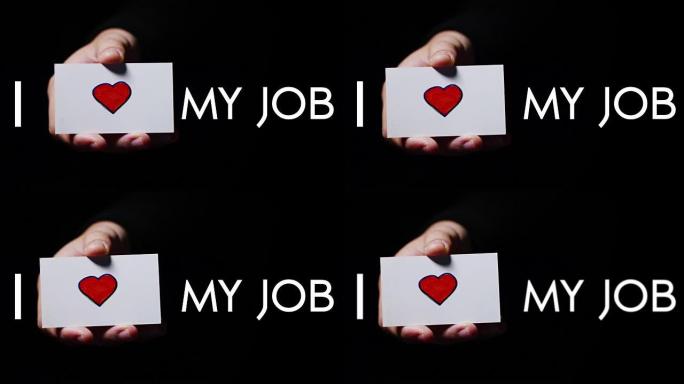 一只手展示一张浪漫的卡片，上面写着 “我爱工作”。概念: 爱，帮助他人，喜欢，热爱他们的工作，热爱他